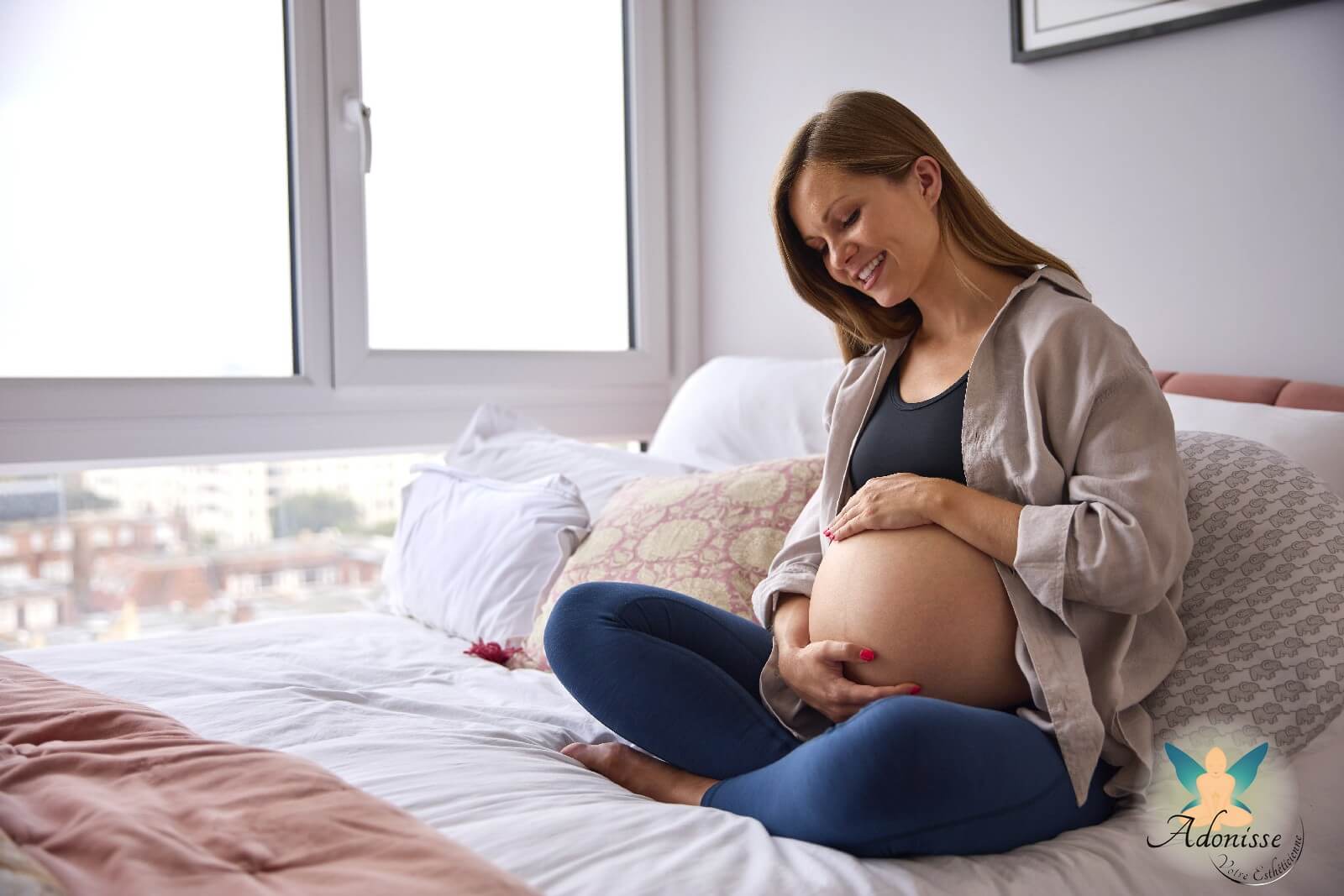 Pregnant woman sitting on her bed